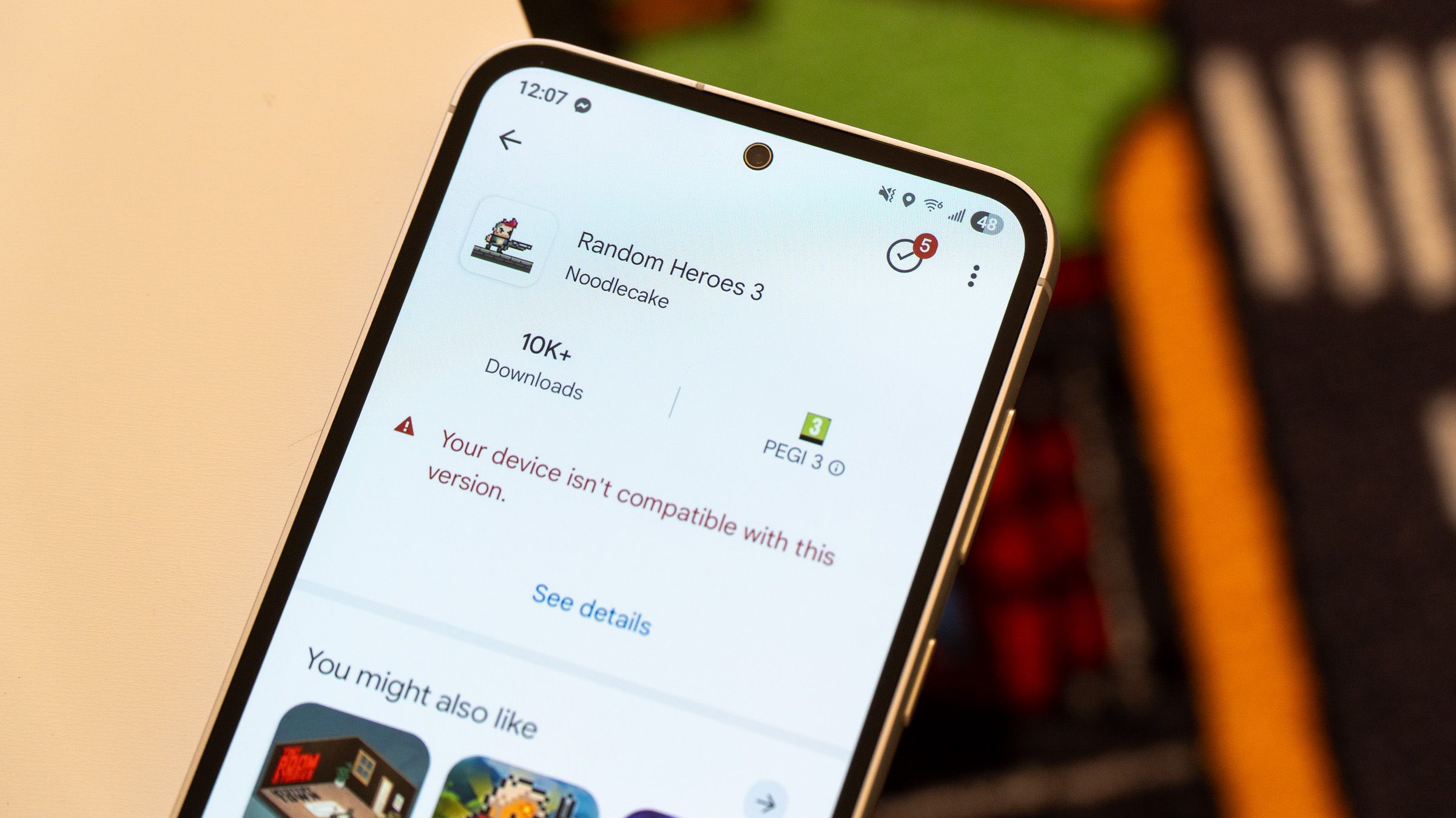 a closeup of a phone on a white surface displaying an incompatible game from the play store