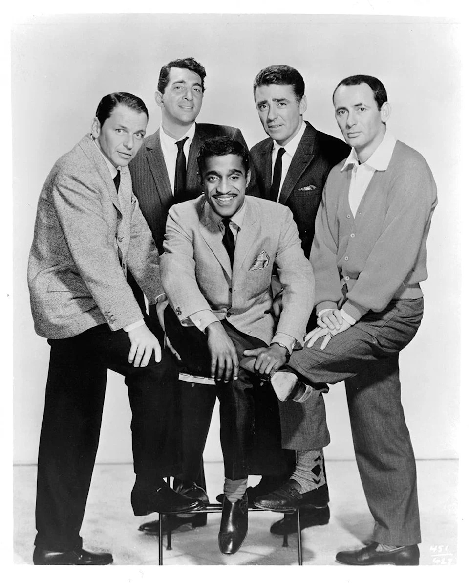 The Rat Pack posing together in matching suits.