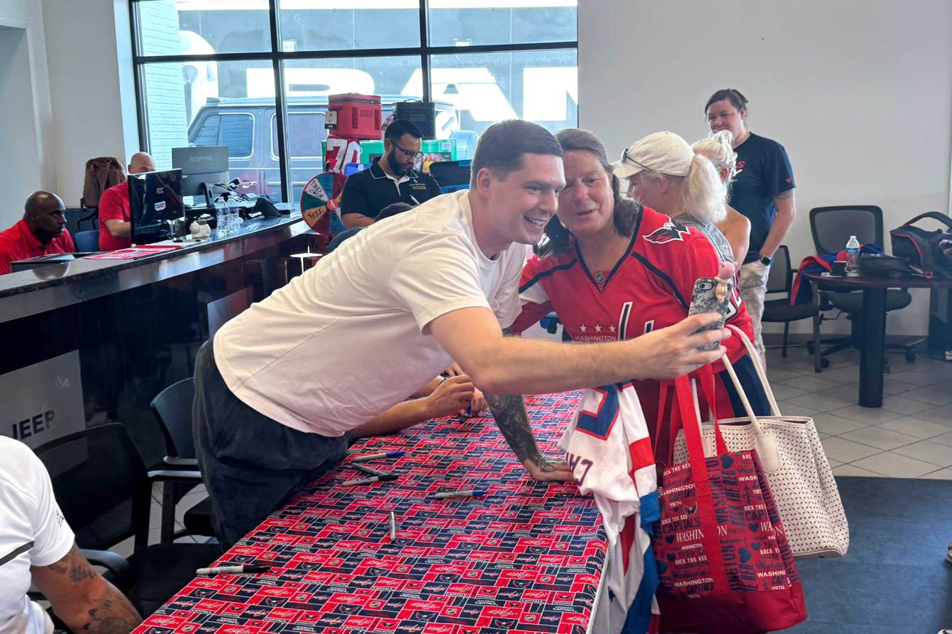 Evgeny Kuznetsov takes a selfie with a Capitals fan
