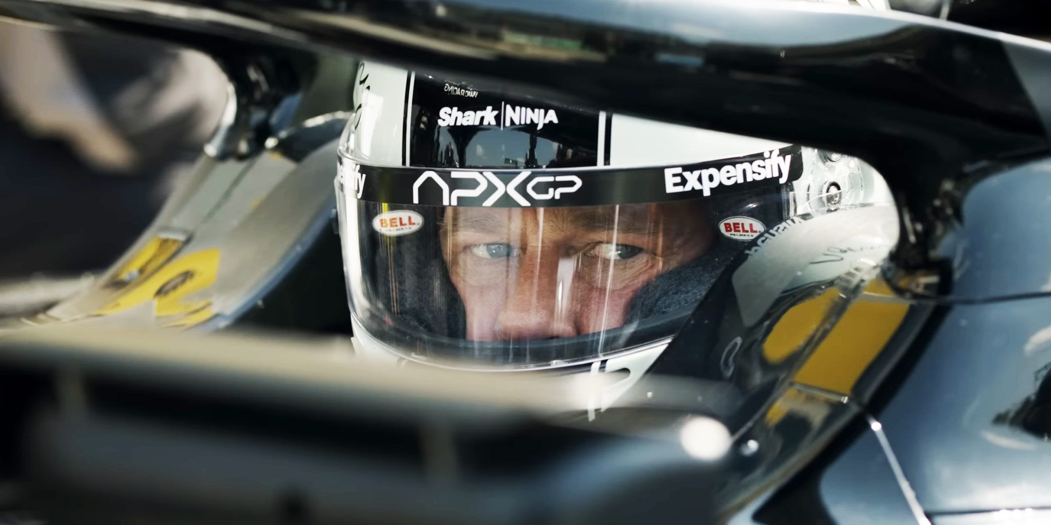 Brad Pitt as Sonny Hayes in the driver's seat of an F1 car in F1 The Movie