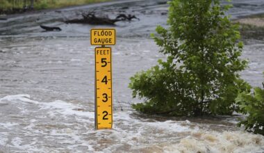 A flood gauge marks the height of water flowing over a farm-to-market road near Kerrville, Texas, on Friday, July 4, 2025. (AP Photo/Eric Gay)