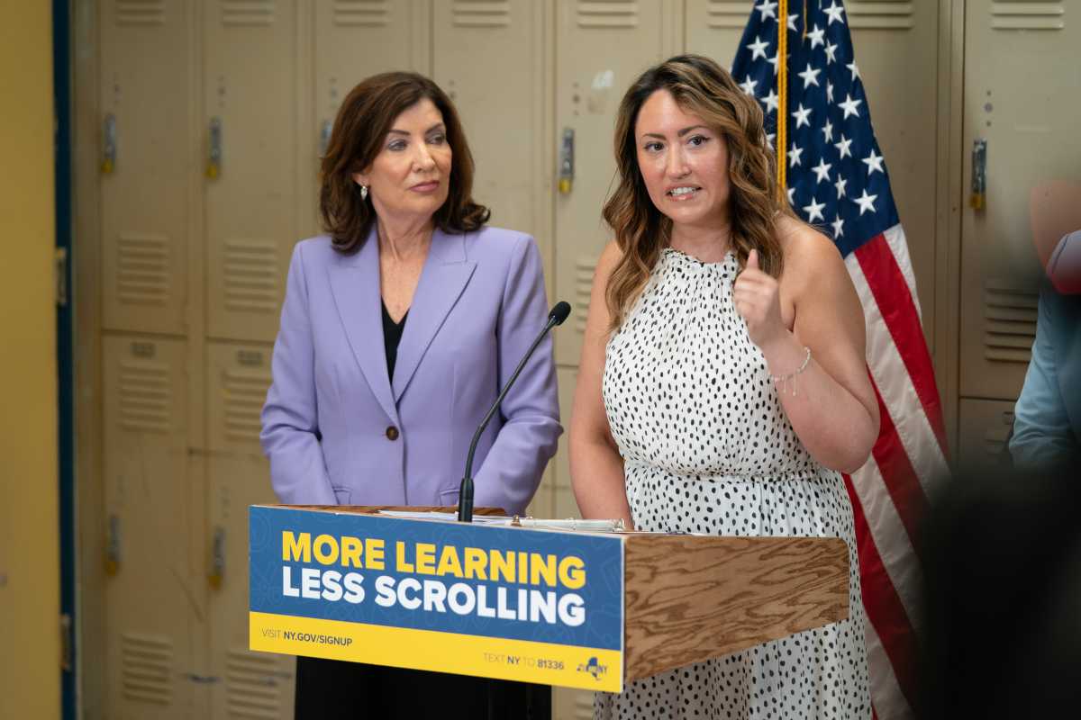 two women speaking at podium about cellphone ban in public schools