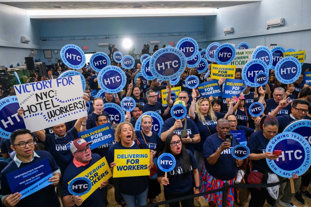 People holding blue and yellow signs celebrating increase in unemployment benefits
