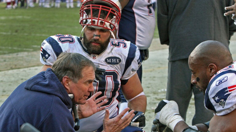 Patriots head coach Bill Belichick (left) talks to defenders Rob Ninkovich (50) and Andre Carter (right) in the second half. The New England Patriots visited the Washington Redskins in an NFL regular season game at FedEx Field.
