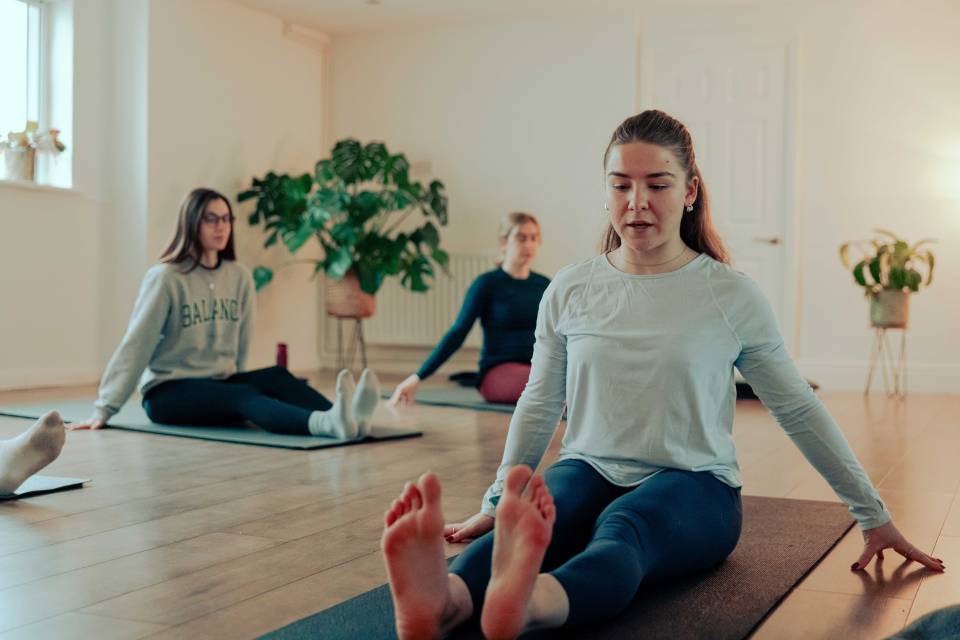 Three women participating in a yoga class.