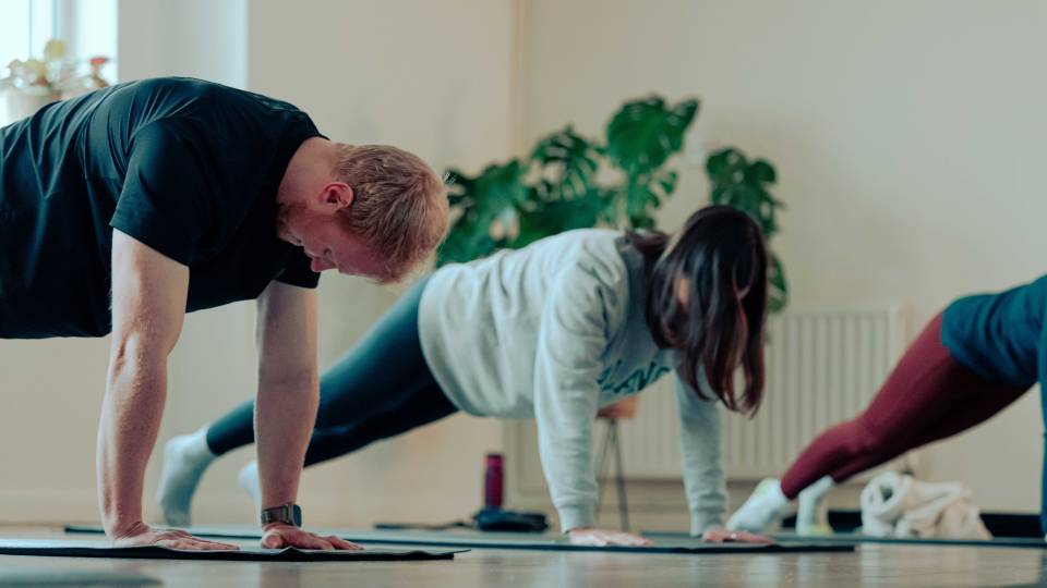 People doing plank exercises in a fitness class.