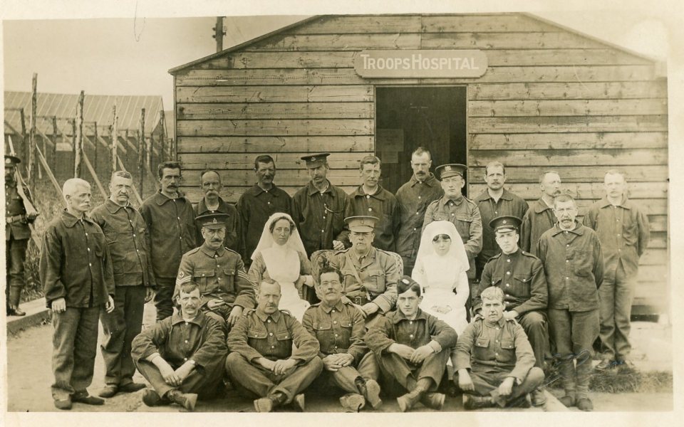 WWI photo of soldiers and nurses outside a troops hospital.