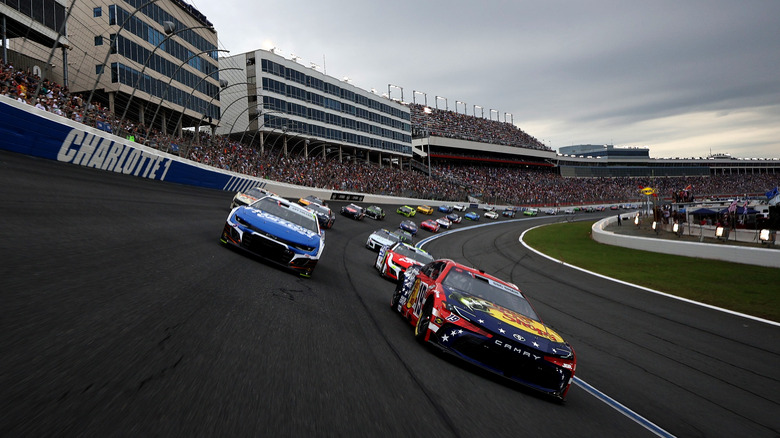 NASCARs rounding a corner in a packed speedyway