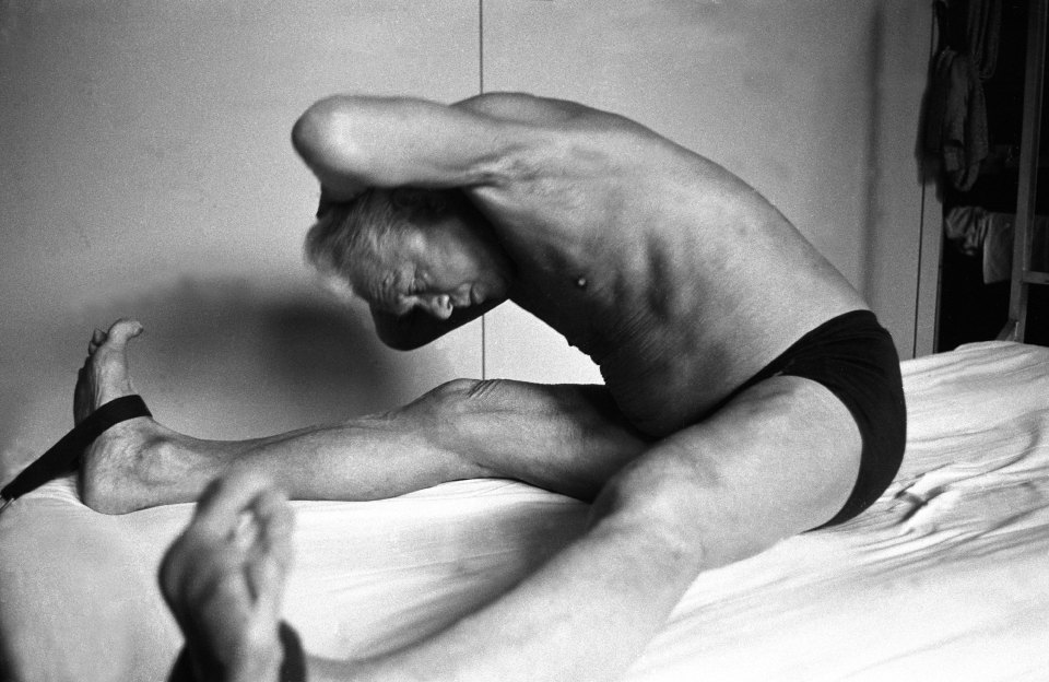 Black and white photo of Joe Pilates demonstrating a Pilates exercise.