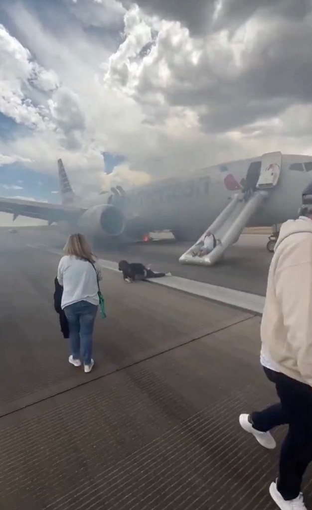American Airlines plane with fire in landing gear; passengers evacuating via inflatable slide.