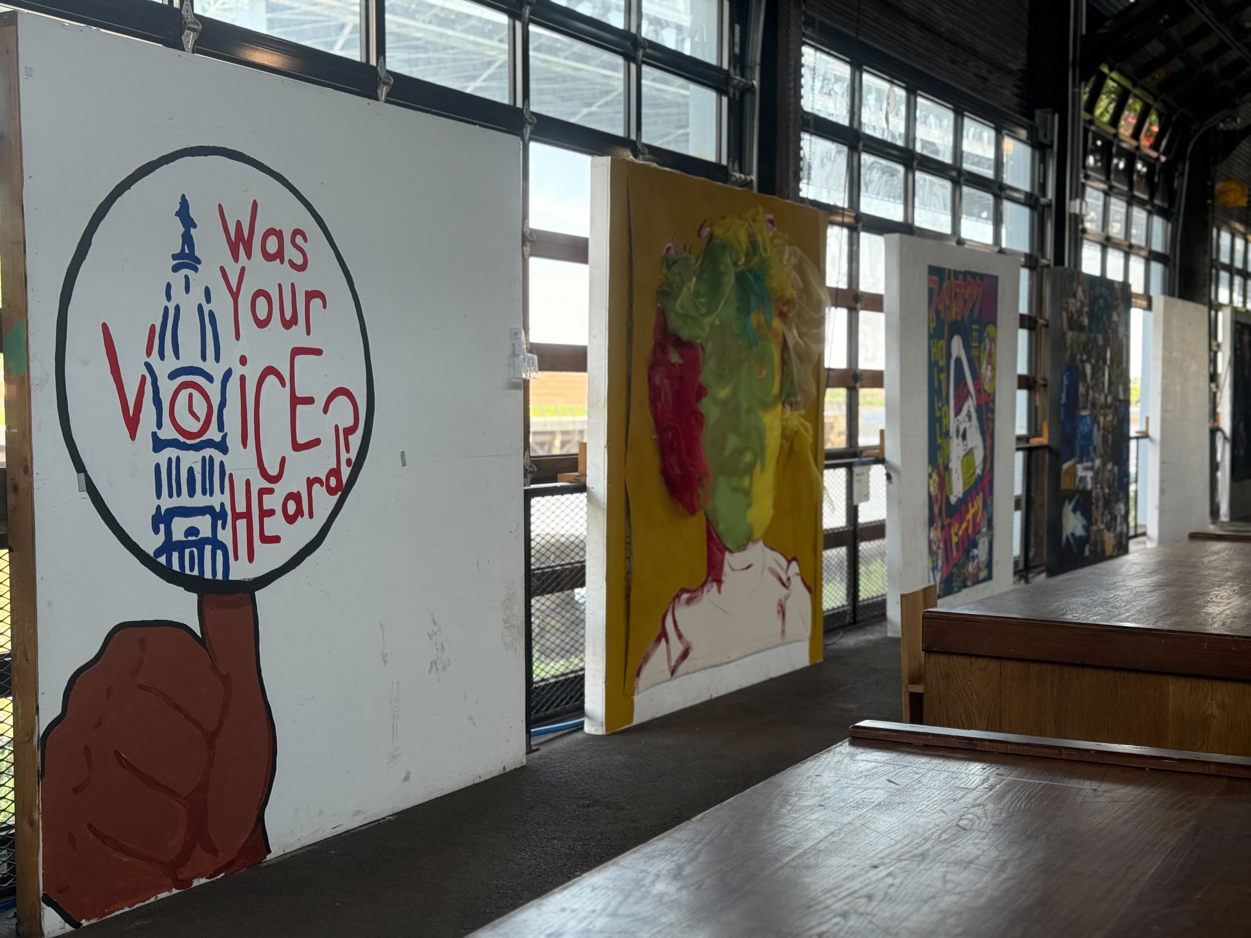 A line of paintings at 2025's Latino Arts and Film Festival in Philadelphia