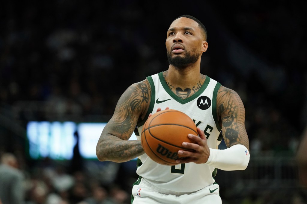 Damian Lillard, Milwaukee Bucks player, holding a basketball.