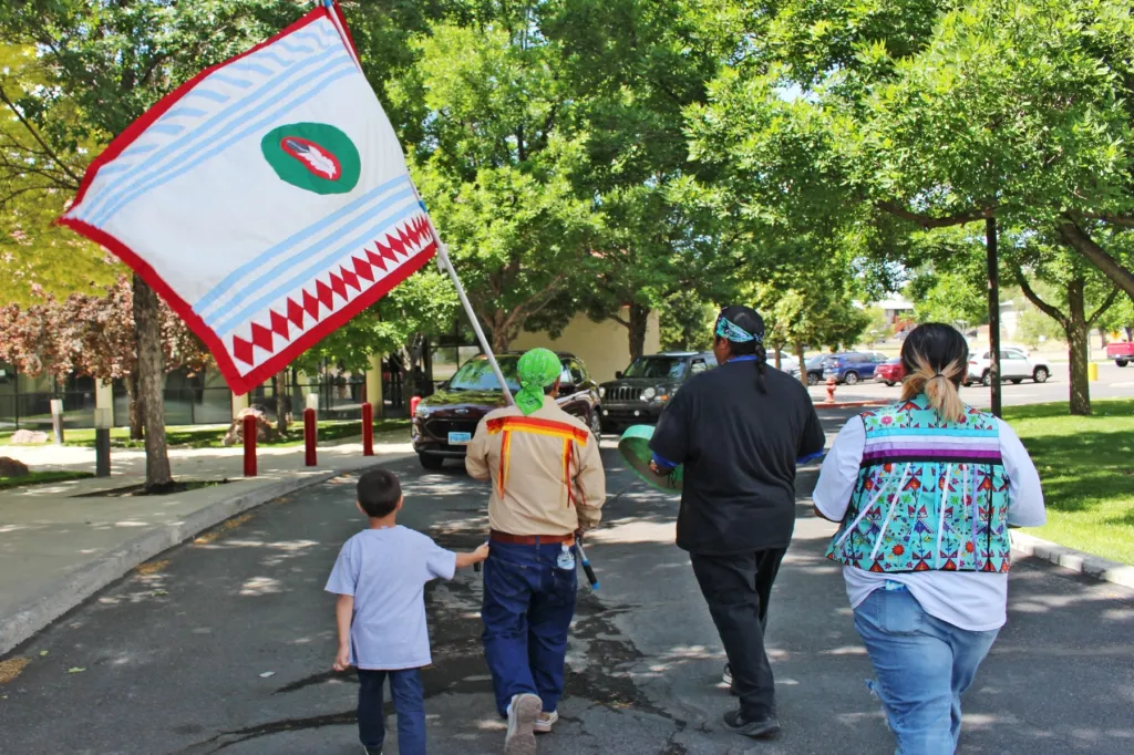Two Spirit Conference attendees carry the Western Shoshone Nation flag during an awareness walk.