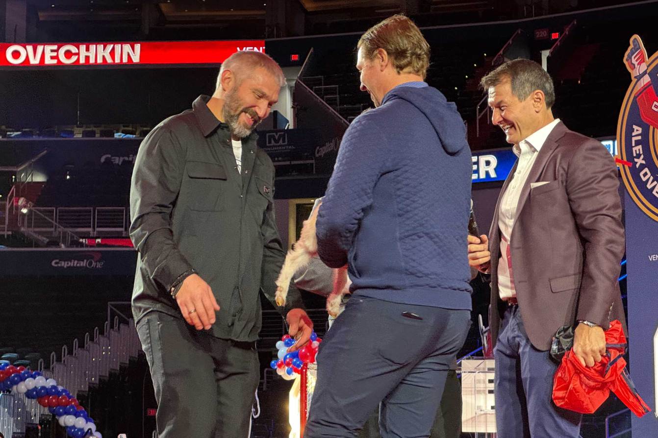 Alex Ovechkin laughs while Nicklas Backstrom presents him a baby goat