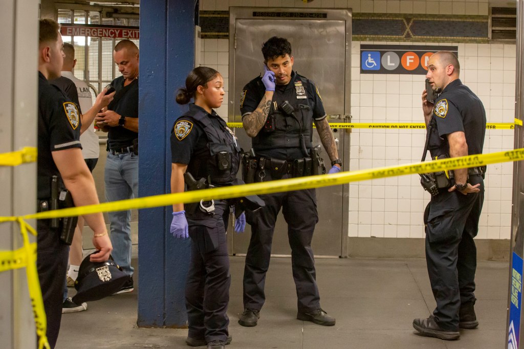 NYPD officers at a subway station crime scene.