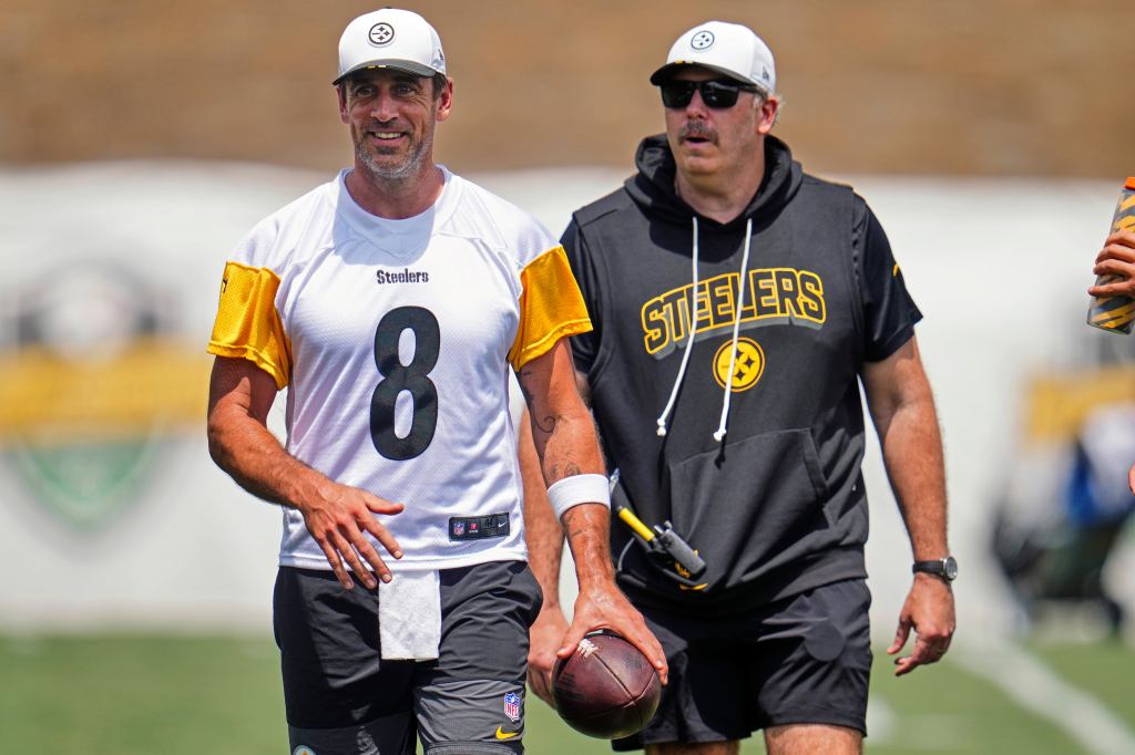 Aaron Rodgers, wearing a Steelers jersey, and an unidentified Steelers coach at practice.