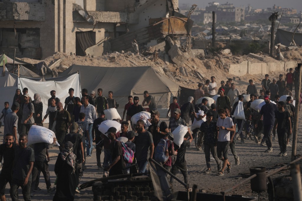 Palestinians carrying sacks of flour in Gaza.
