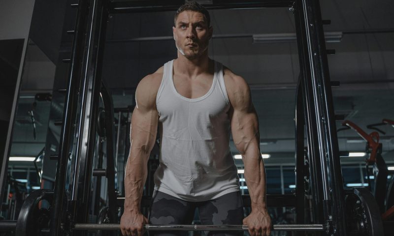 man lifting barbell strong muscle