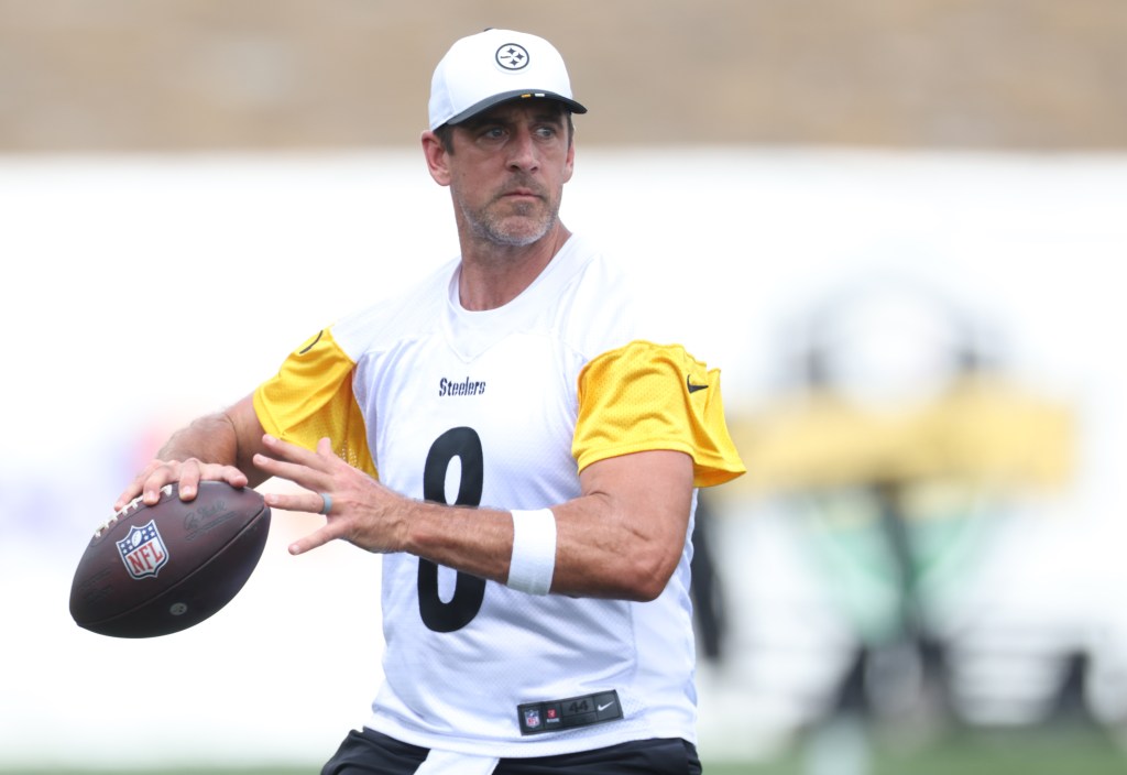 Aaron Rodgers, wearing a Steelers jersey, throws a football.