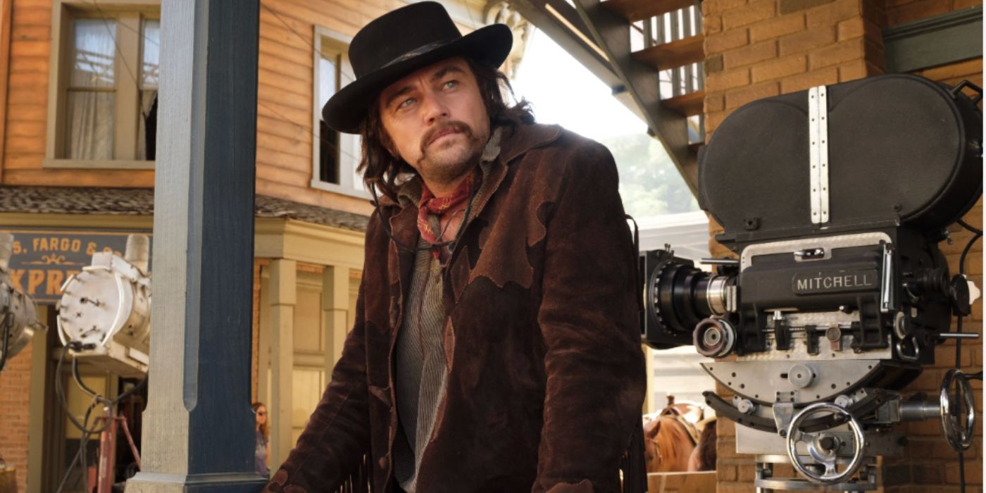 Leonardo DiCaprio as Rick Dalton wearing a cowboy hat and brown jacket on set in 'Once Upon a Time in Hollywood'