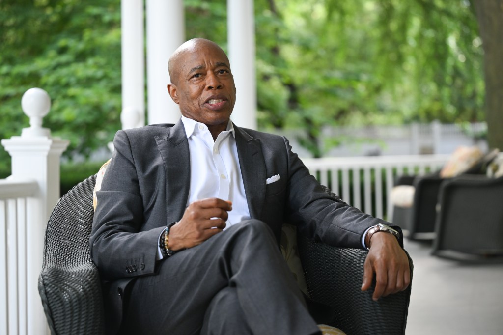 Mayor Eric Adams sitting on a porch.