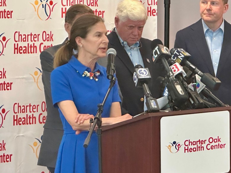 Woman in blue dress speaking into microphone