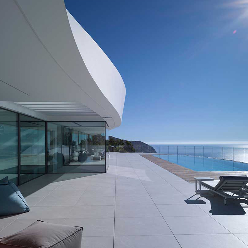 curved house's sinuous facade traces mountainous terrain in spain