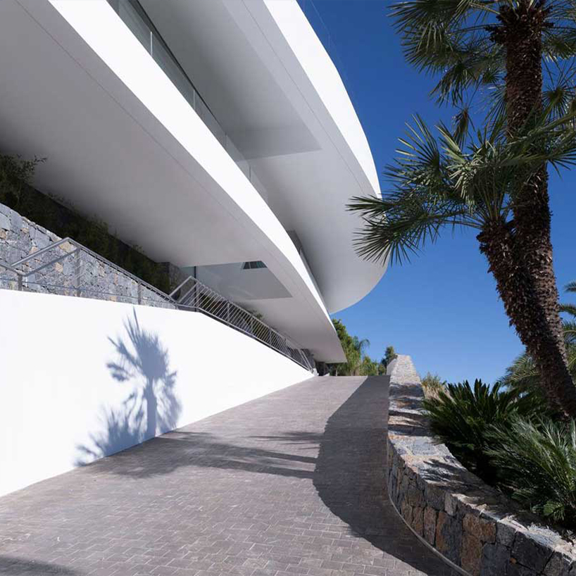 curved house's sinuous facade traces mountainous terrain in spain