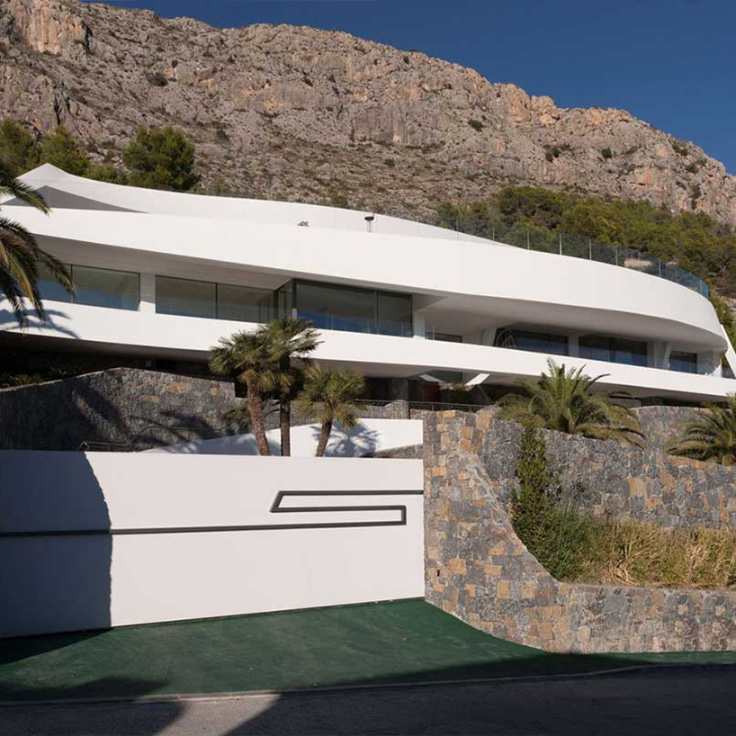 curved house's sinuous facade traces mountainous terrain in spain