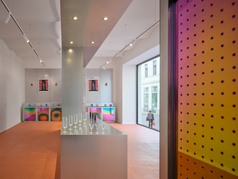 iridescent titanium panels cast chromatic reflections within info desk by KOGAA in brno
