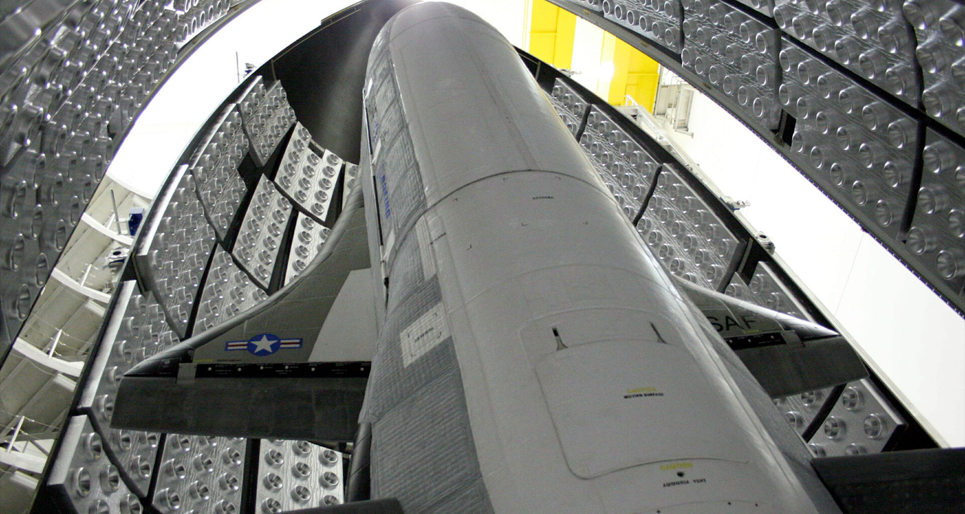 a winged space plane stands up inside its protective fairing before being sealed up for launch