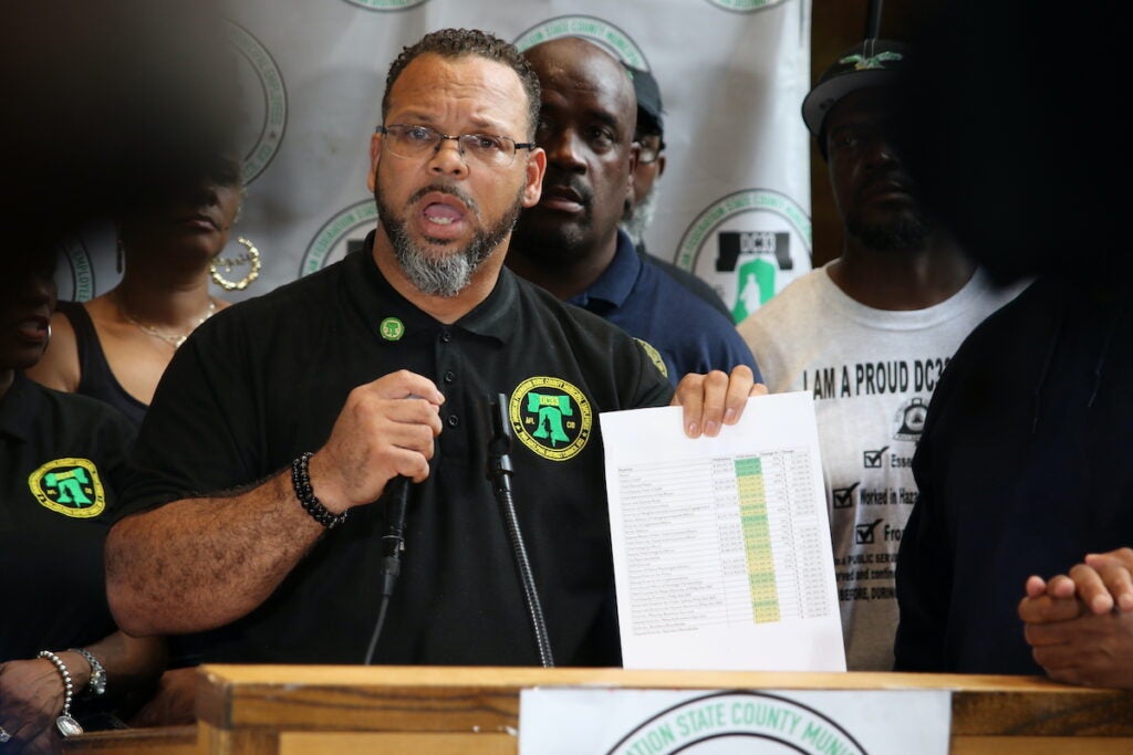 Greg Boulware holds up a list of pay raises to members of Mayor Cherelle Parker's administration