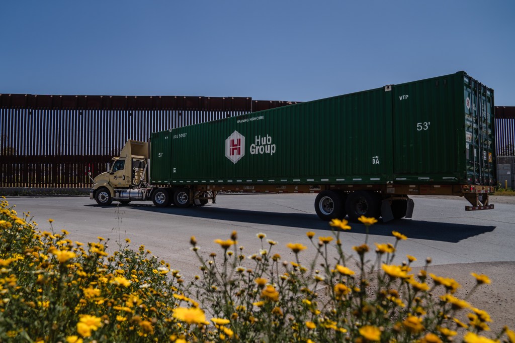 A cargo truck passes the border wall that divides the United States and Mexico in Otay Mesa on April 26, 2023.