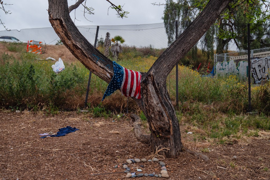 An American Flag hangs on a tree a block away from Neil Good Day Center in the East Village on May 23, 2023.
