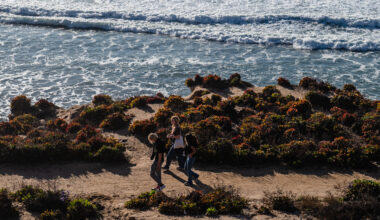 People walk near the ocean in Del Mar on Jan. 2, 2024.