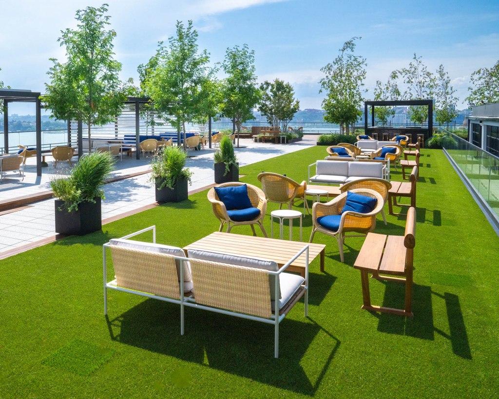 Yacht Club rooftop patio with wicker furniture and artificial turf.