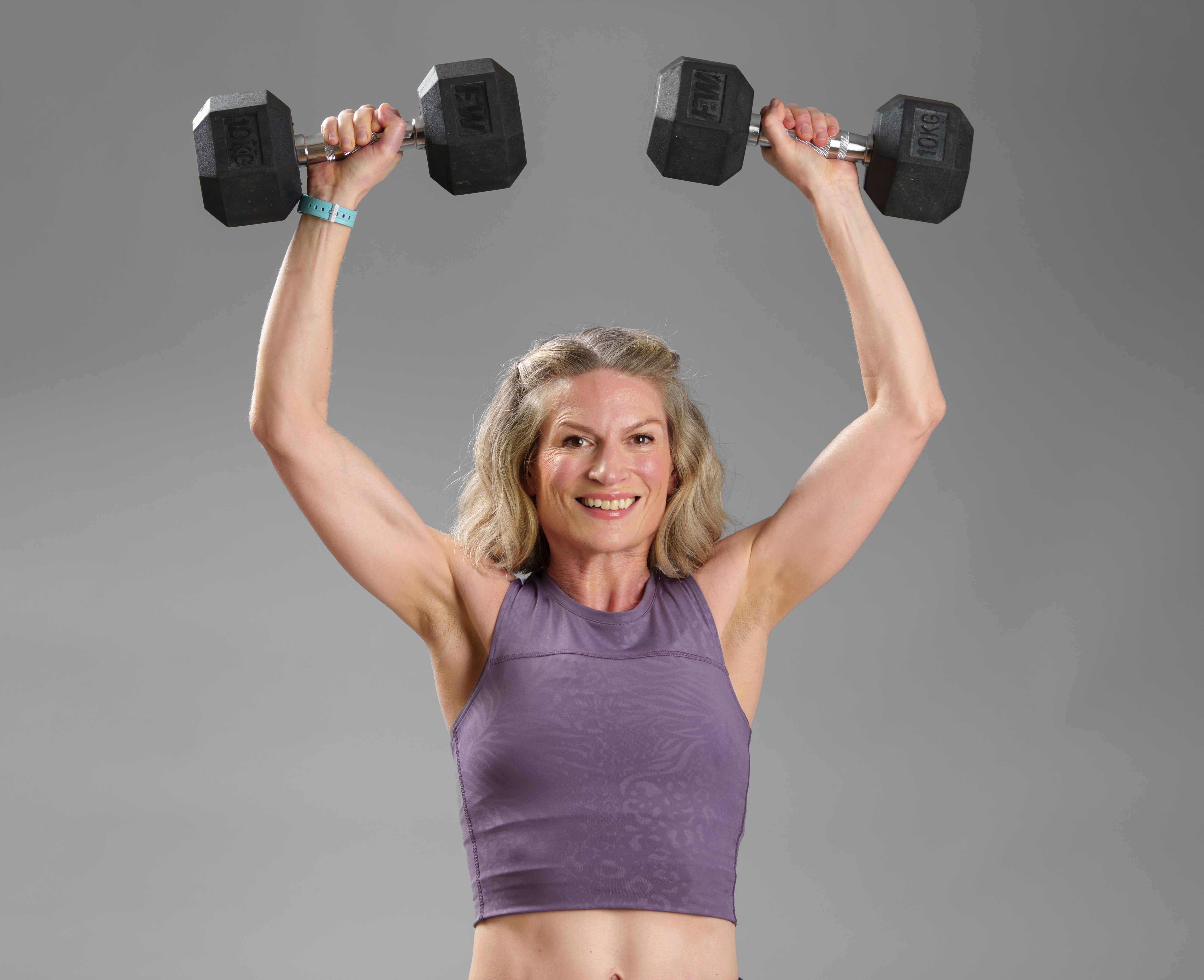 Woman lifting weights above her head.