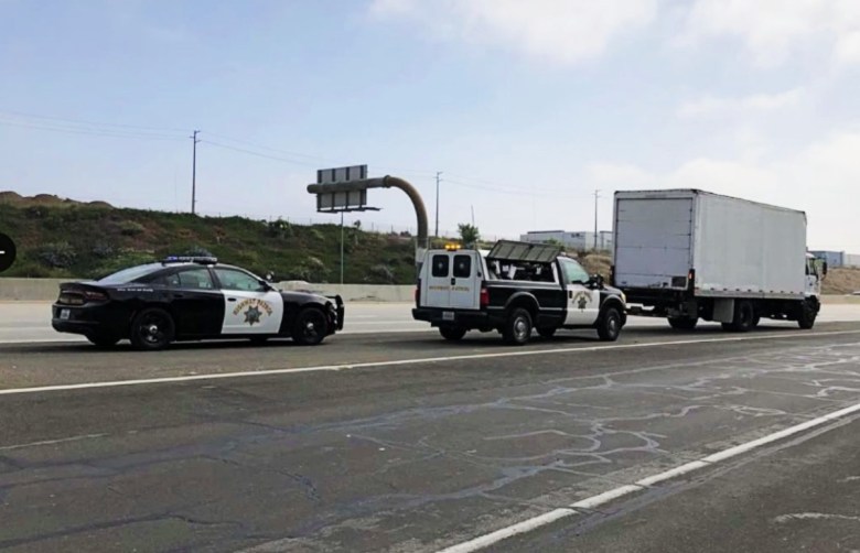 Two CHP vehicles behind a white truck with empty traffic lanes to the right.