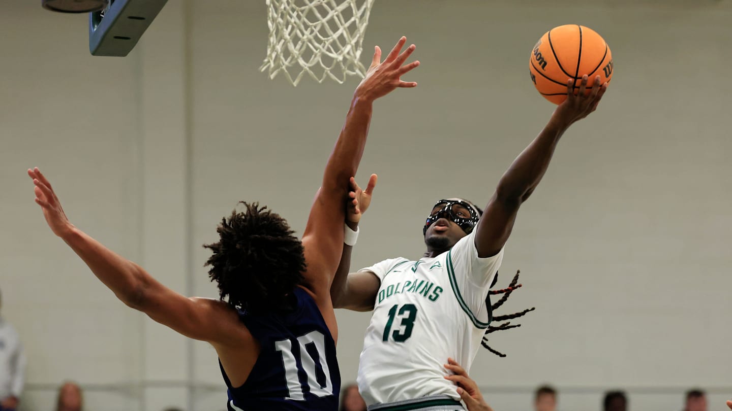 Jacksonville Dolphins guard Robert McCray V (13) drives the lane against North Florida Ospreys forward Josh Harris (10) during the first half of an NCAA men’s basketball matchup Saturday, Feb. 1, 2025 at Jacksonville University in Jacksonville, Fla. [Corey Perrine/Florida Times-Union]