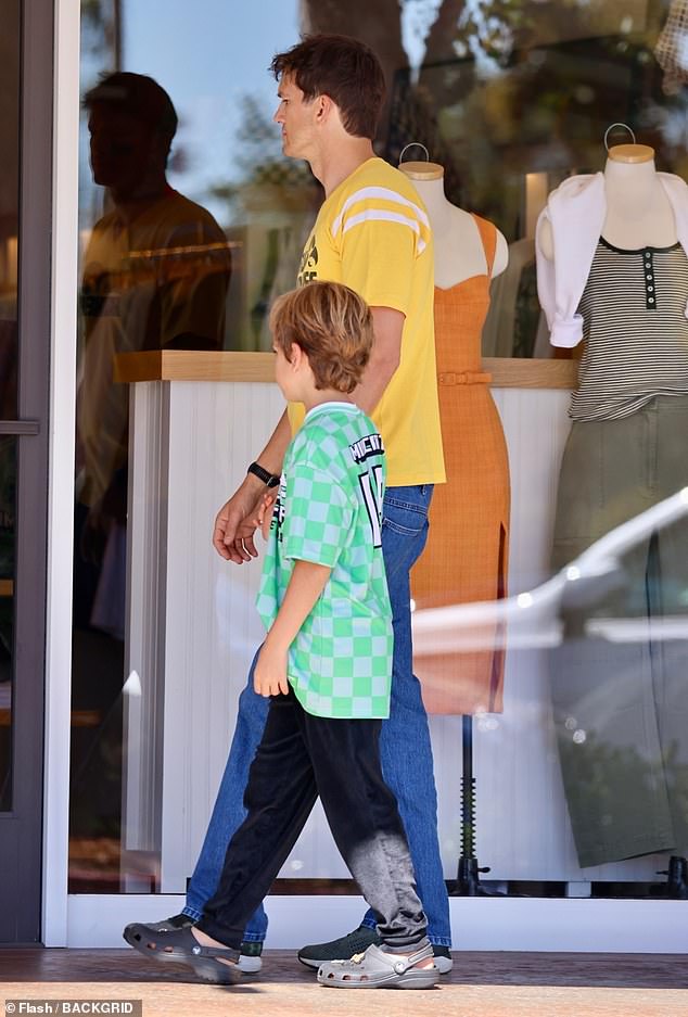 Kutcher, 47, actor looked relaxed in a yellow Iowa Hawkeyes T-shirt with a pair of straight leg jeans. His son Dimitri, eight, showed his own team spirit wearing a green and gray sports jersey over black joggers and Crocs