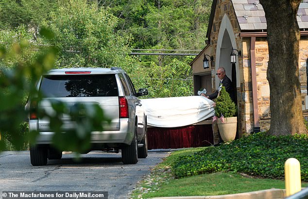 Maguire's coffin is pictured being carried into St. John Vianney Catholic church