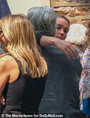 Kylie pulled her father-in-law in for a hug as they exited the church following the service