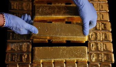 Gold inches lower as dollar gains, markets eye Fed appointments