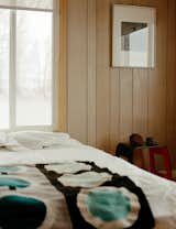 Surrounded by windows on three sides, a bedroom with wood-paneled walls retains vestiges of its sixties past and remains a work in progress. While debating the long-term layout of his now abode, Rael has made homey additions to his quarters, like a painted canvas in adobe by his partner, the artist Joanna Keane Lopez, found rocks, and one of three prints from Icy & Sot, the multidisciplinary art practice of Iranian-born, Brooklyn-based brothers Saman and Sasan Oskouei.