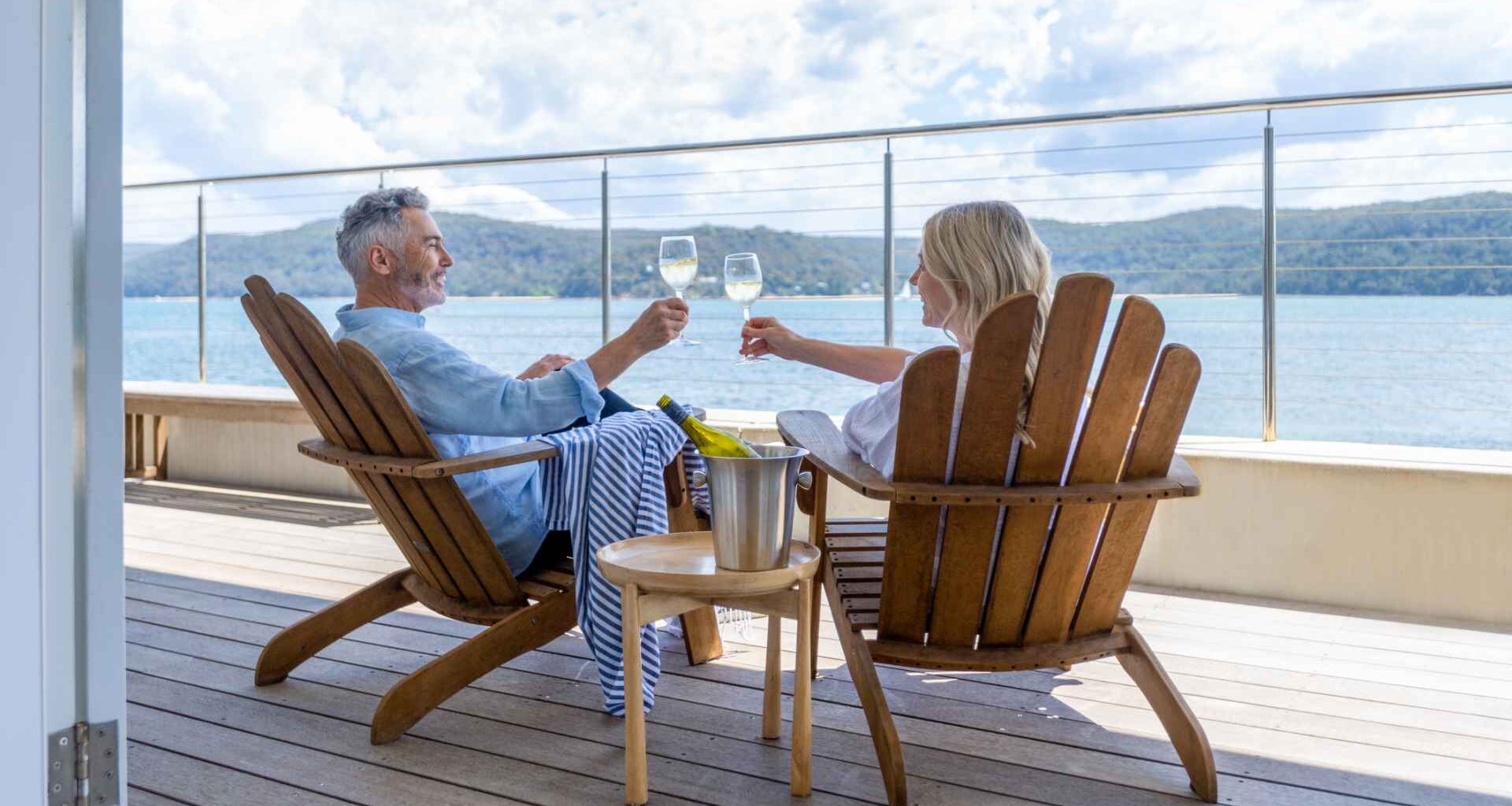 Mature couple drinking wine out on the deck.