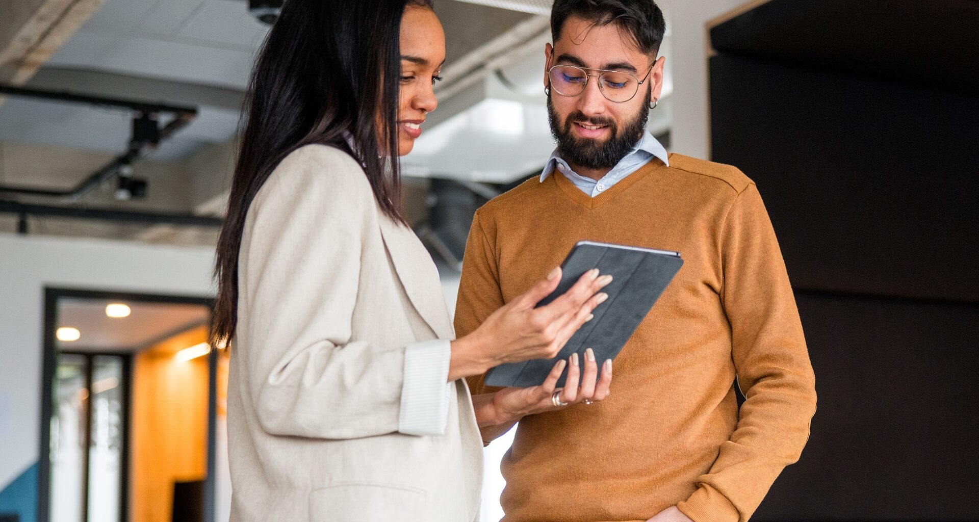 Shot of two business professionals standing in an office and reviewing some financial data on an electronic tablet
