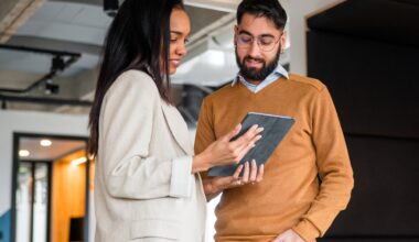Shot of two business professionals standing in an office and reviewing some financial data on an electronic tablet
