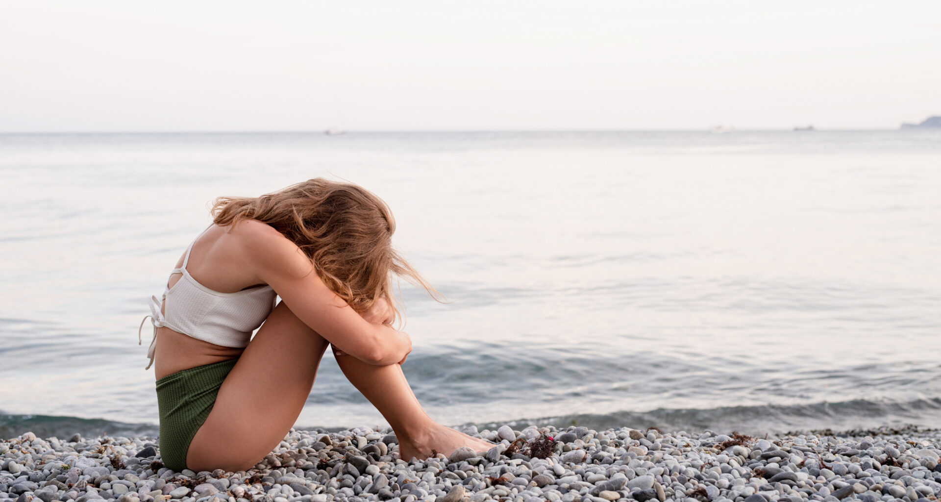 Stock image of sad woman on beach.