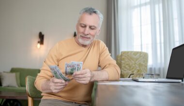 Gray-haired man standing and counting money stock photo