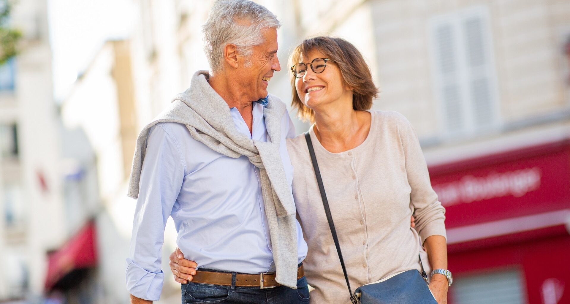 Smiling older couple walking arm-in-arm outdoors, symbolizing retirement planning, financial freedom, and enjoying life after reaching savings goals.
